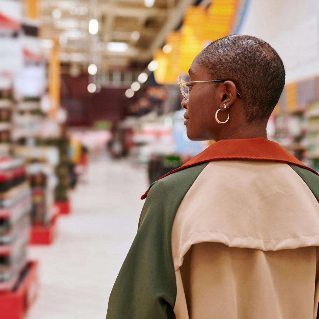 A woman is standing in a supermarket aisle.